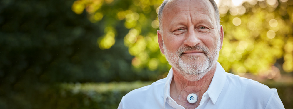 man with a neck stoma using provox life energy hme outside