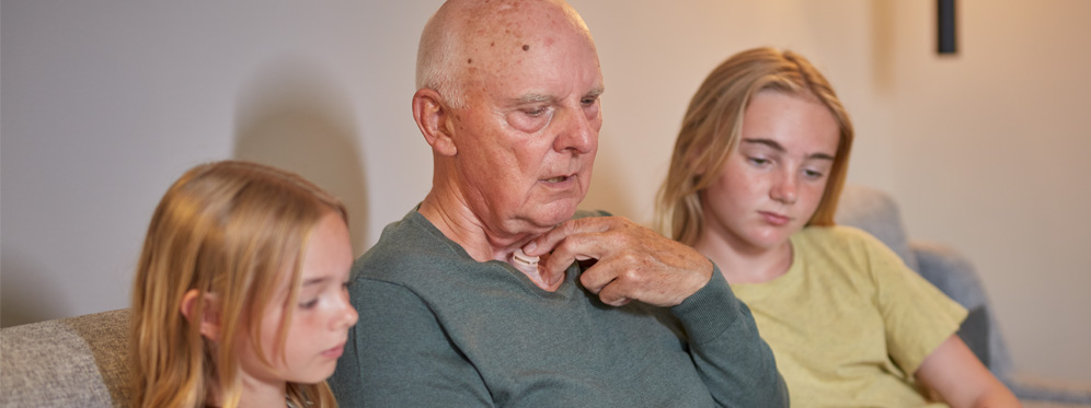 man uding provox hme reads to kids on couch